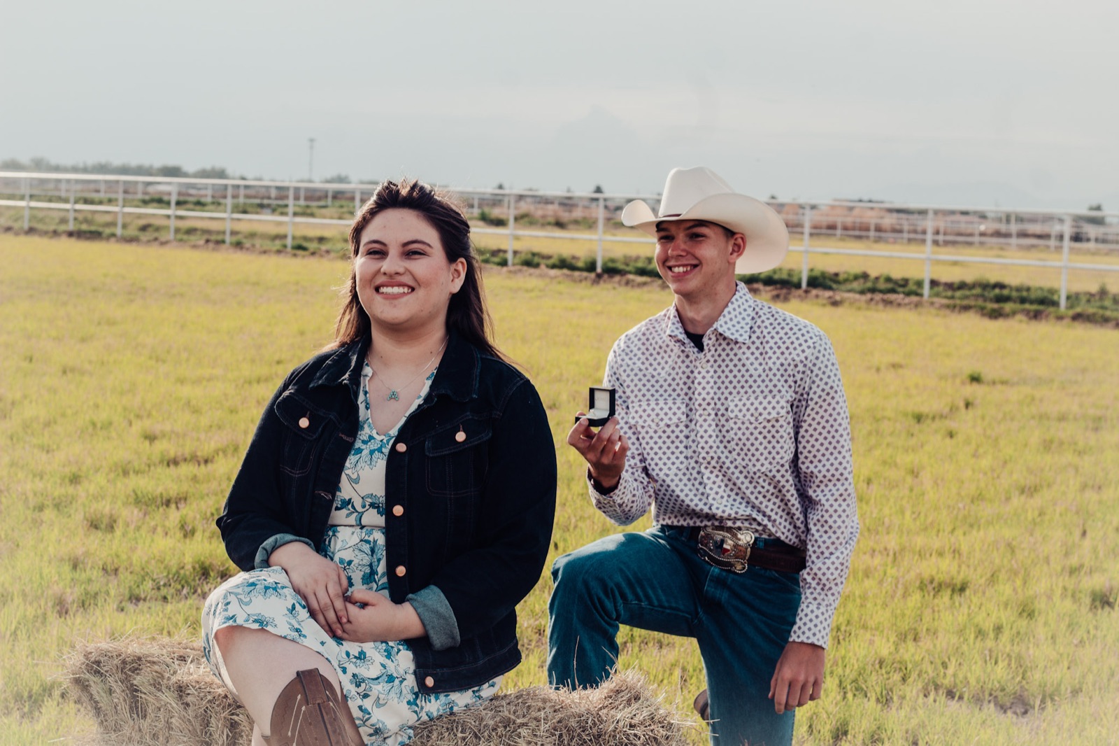 Man kneeling with a ring box during a proposal at a ranch