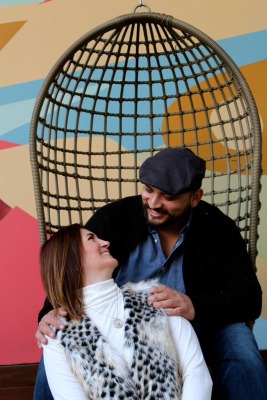 Couple in a hanging chair by a mural