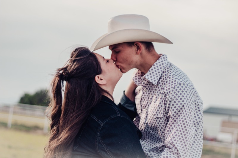 Couple in cowboy hats sharing a kiss