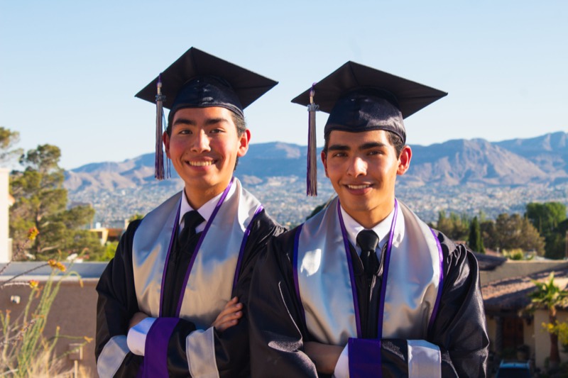 Two graduates above the El Paso skyline