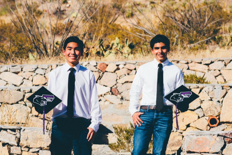 Graduates by a stone wall