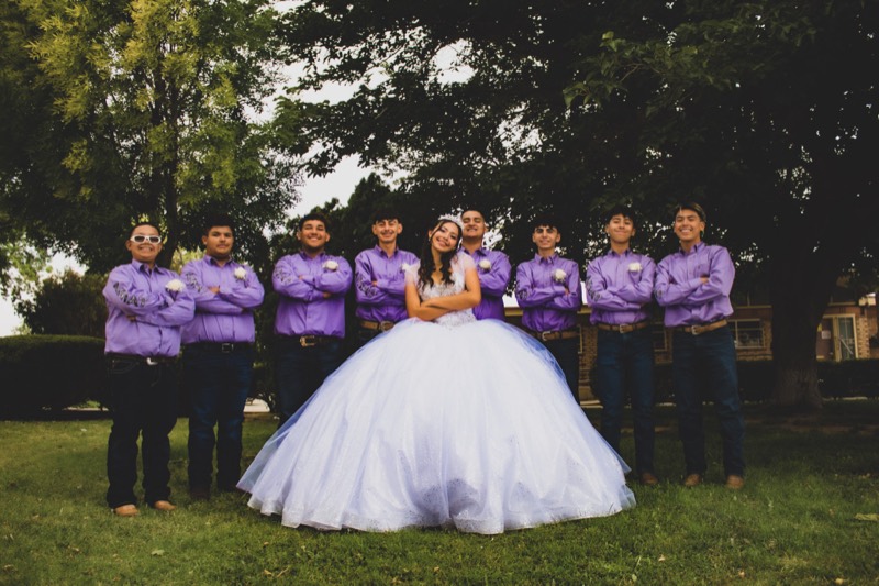 Quinceañera with her court dressed in purple