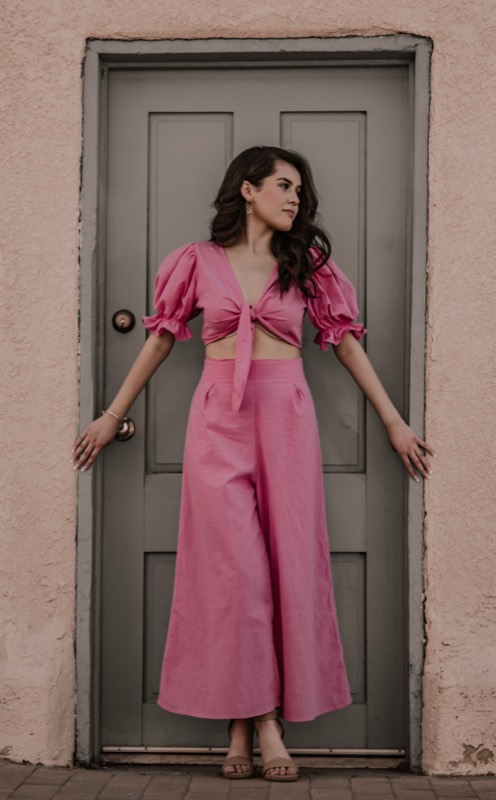 Quinceañera in a pink dress at a doorway