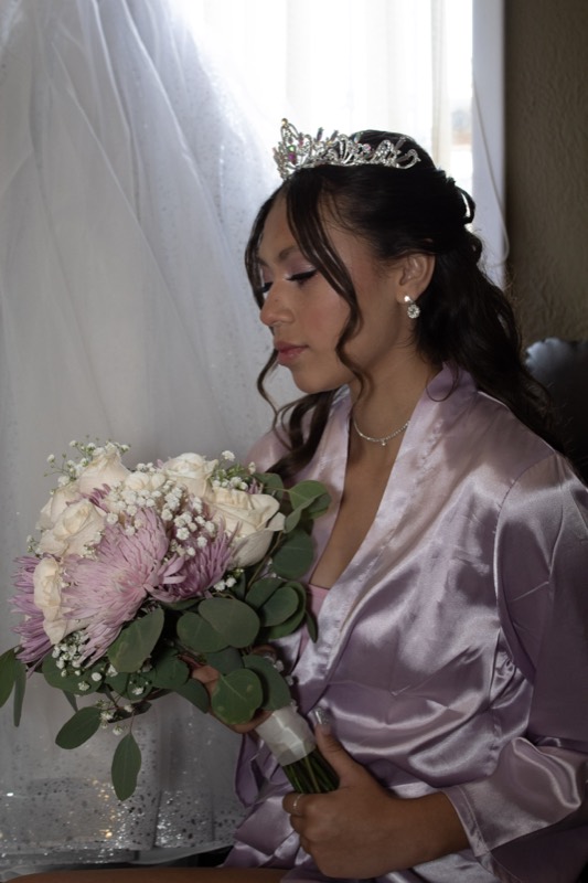 Bride in her robe holding the bouquet