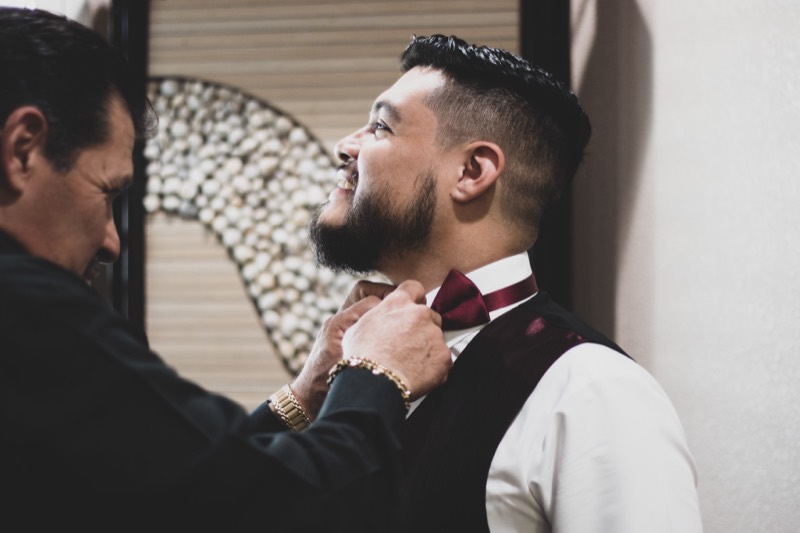 Groom adjusting his bow tie