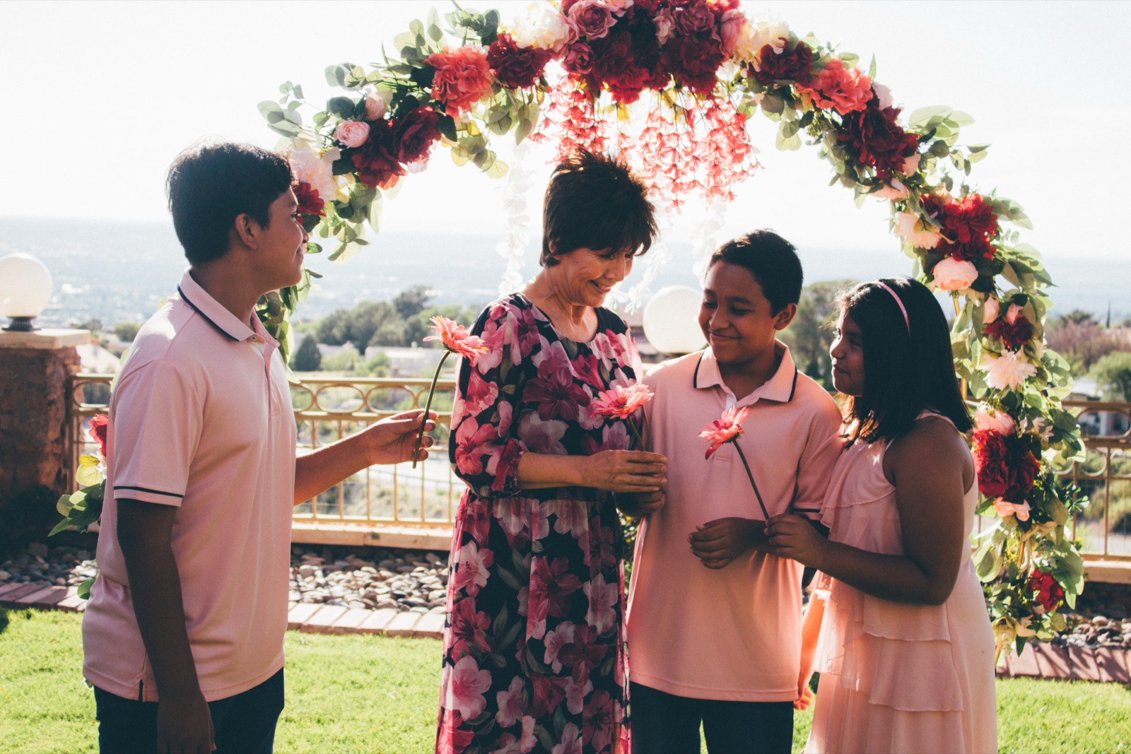 Wedding ceremony under a floral arch photographed by K&M